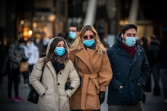 Des personnes circulent dans la rue masqués à cause de la pandémie.