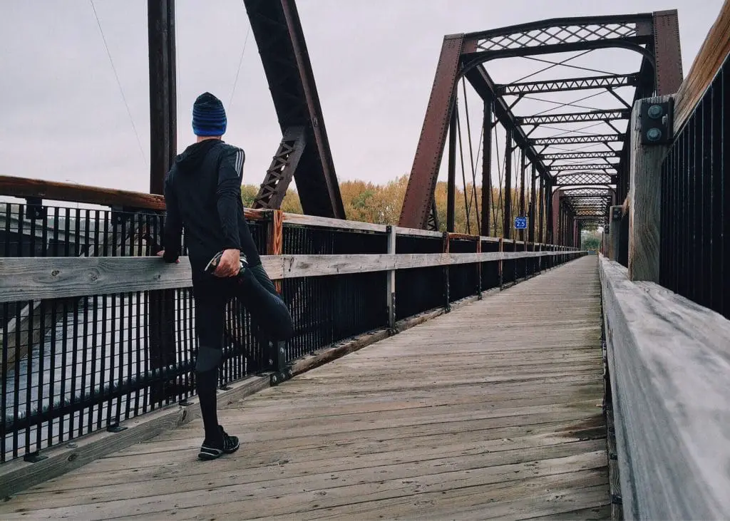 Coureur sur un pont en train de s'étirer