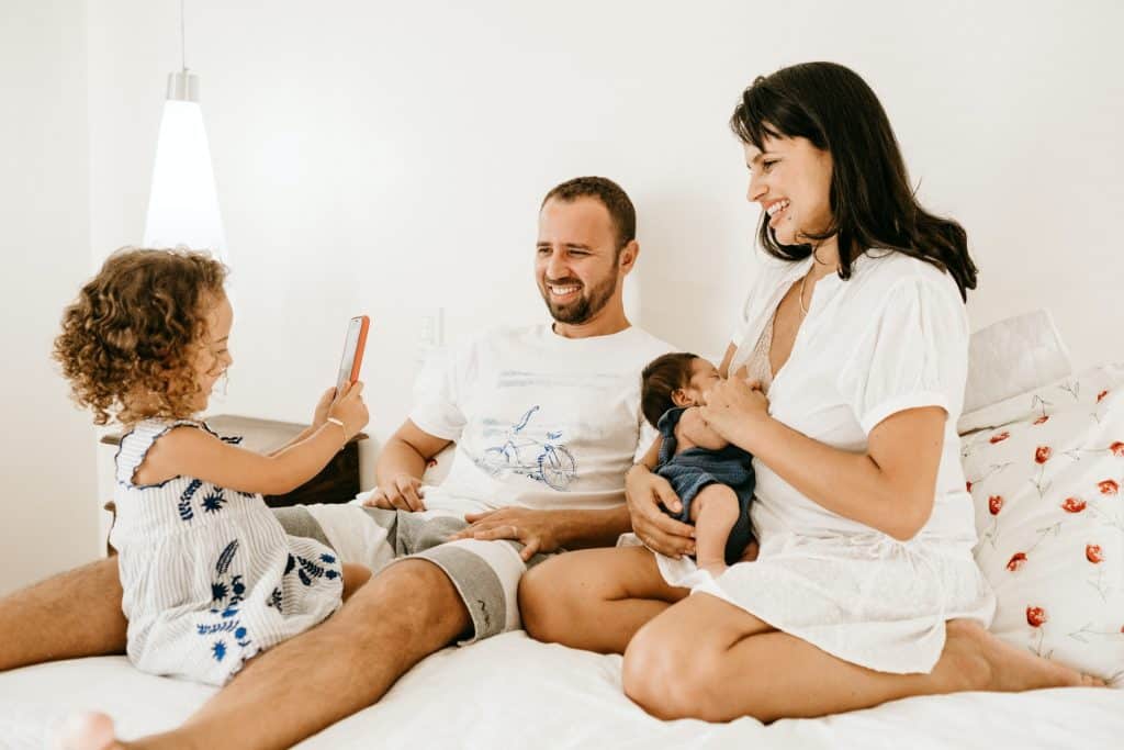 Jeune famille dans leur salon, s'amusant car sereine d'être couverte par une mutuelle