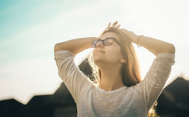 Jeune femme avec des lunettes profitant d'un bain de soleil